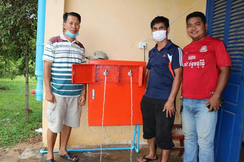 Local partner staff installing a water system in Cambodia