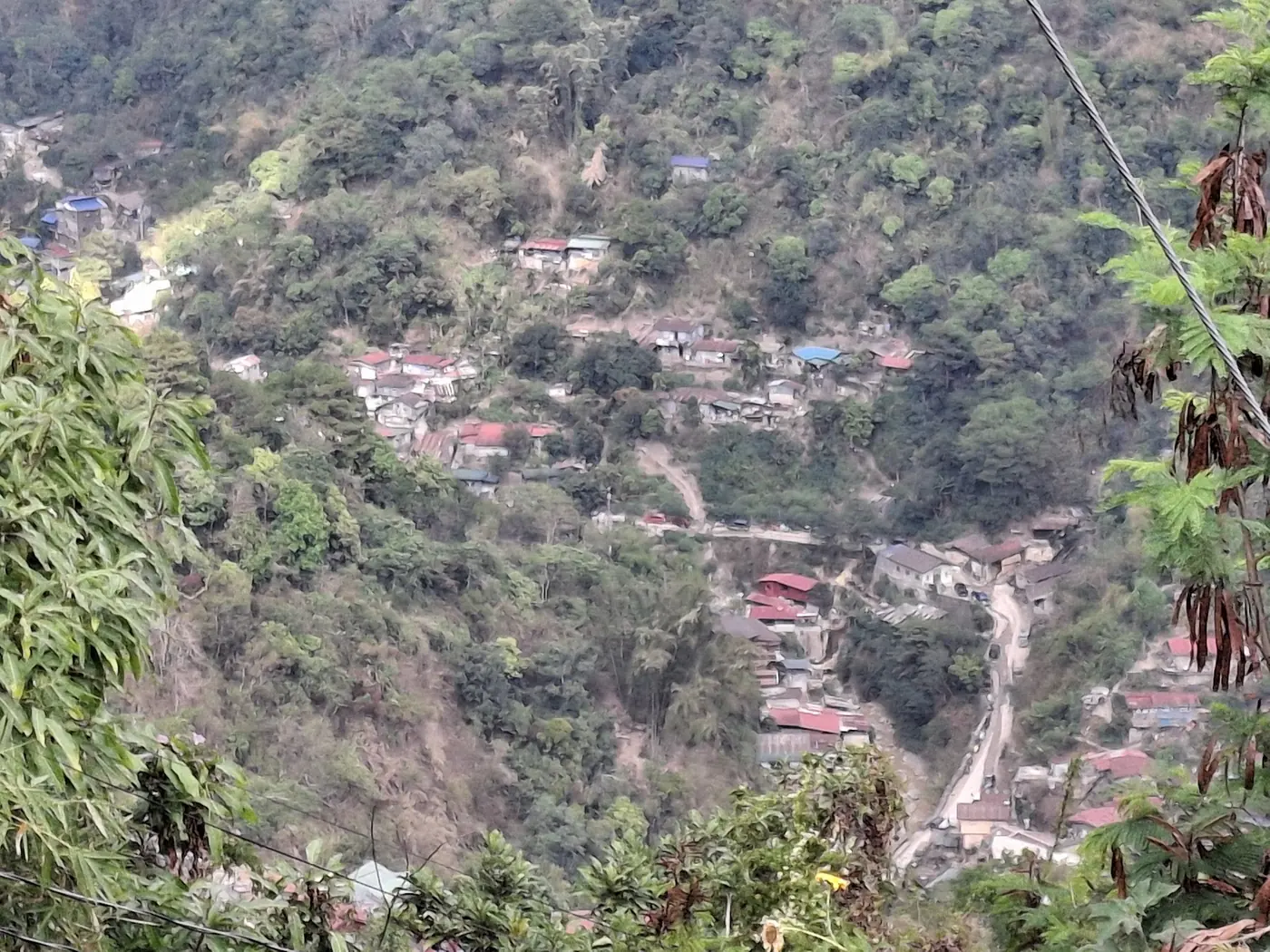 Artisanal gold mining site with visible acid mine drainage running into a stream