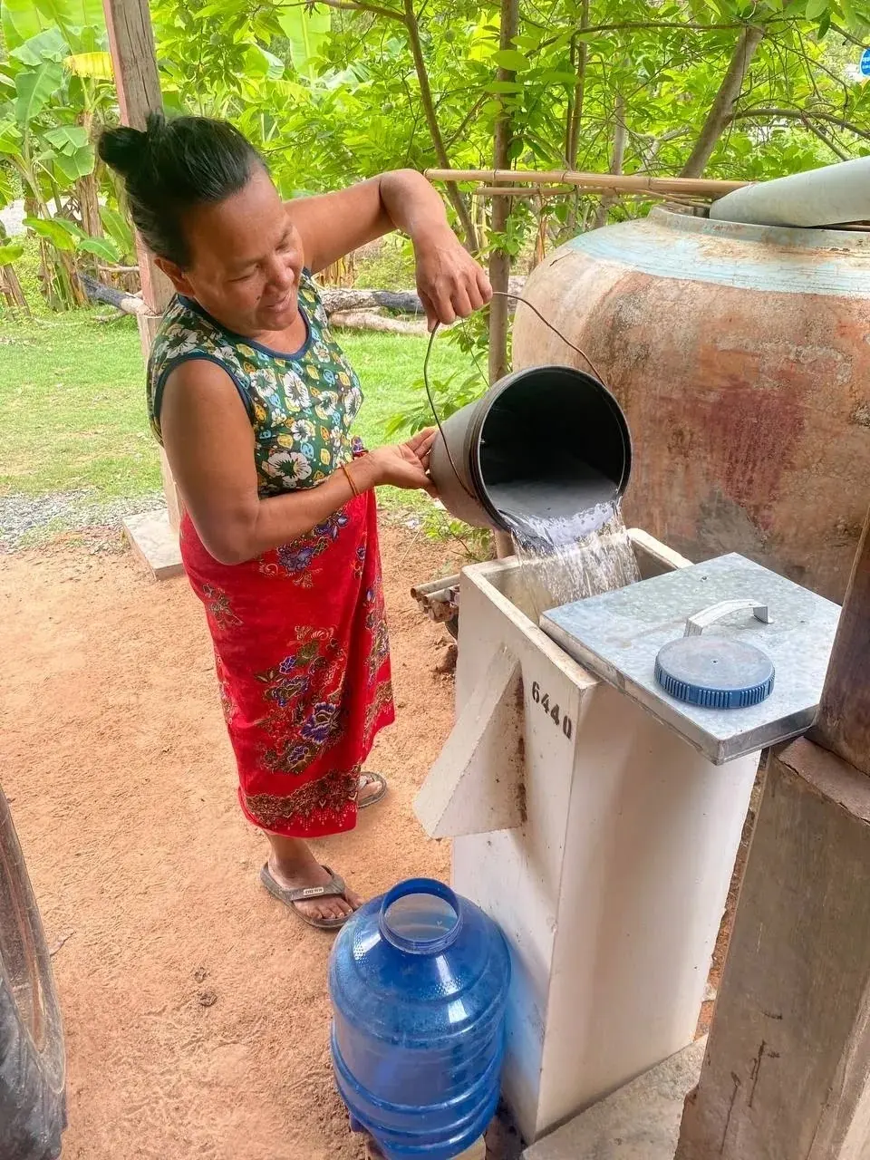 A family pours water into their biosand filter