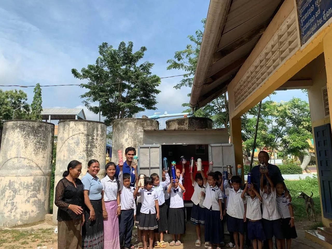 A school community gathers beside its water system