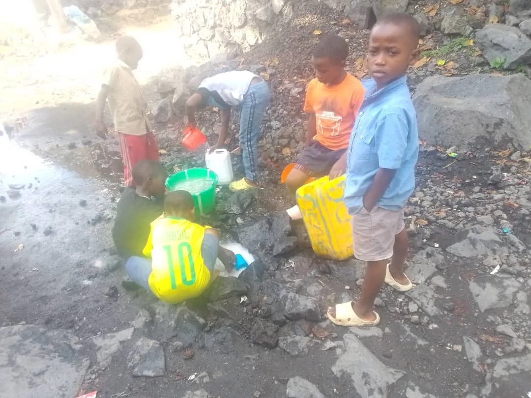 Children fill jerrycans at a community water point