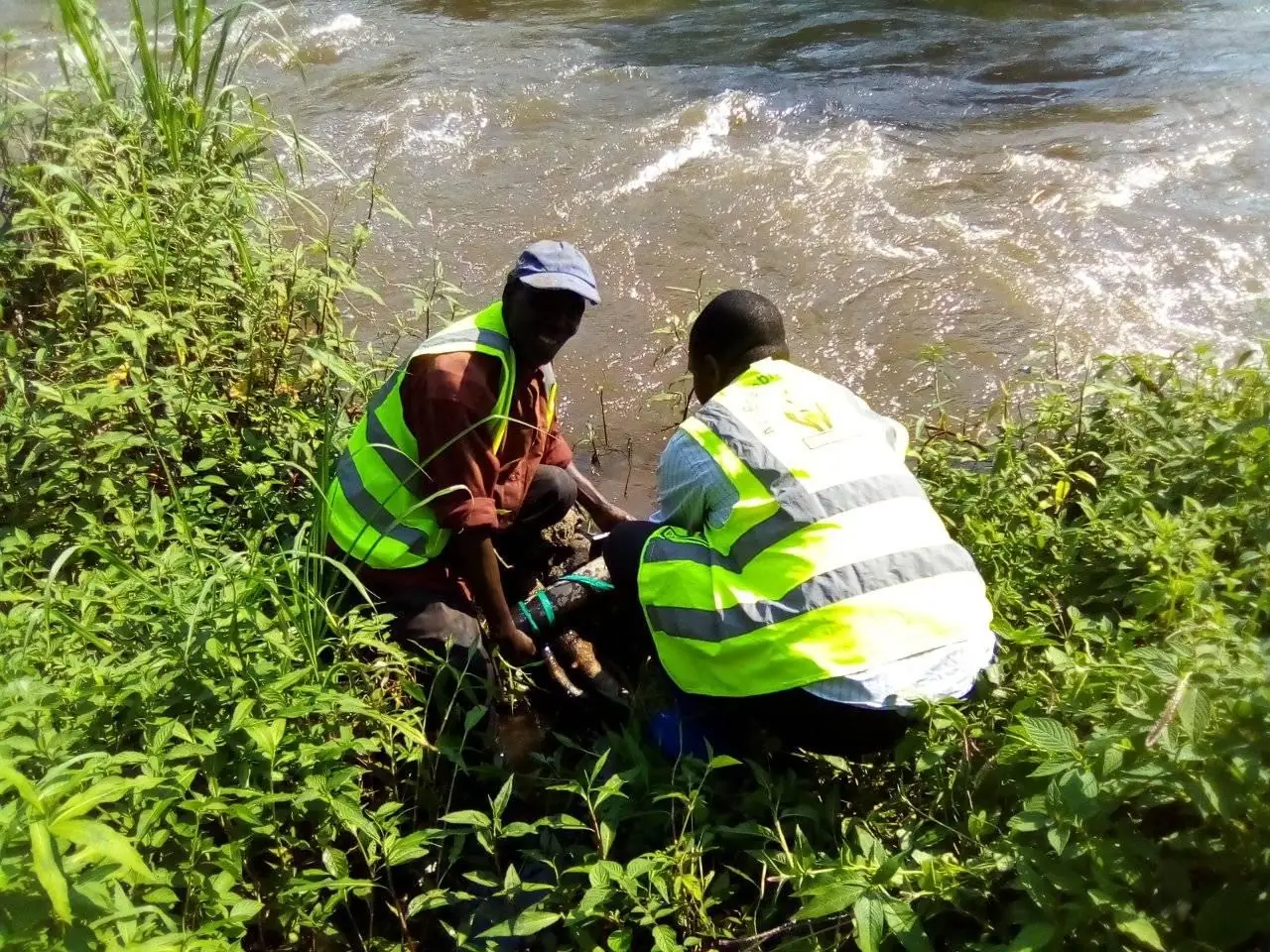 Field-team members assess a riverbank water source