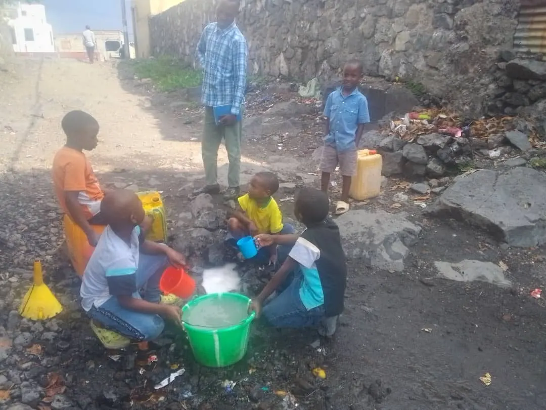 Children collect water at an open source