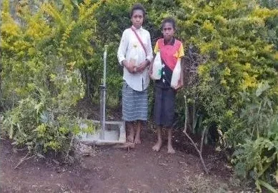 Two girls at a tap stand in the Eastern Highlands