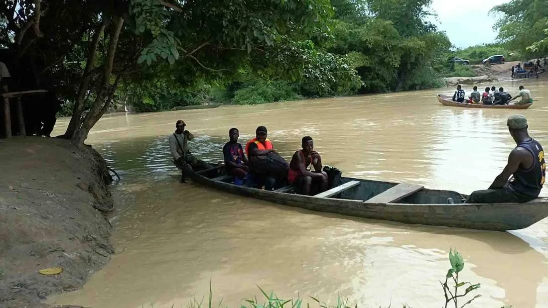 Residents cross a river by canoe